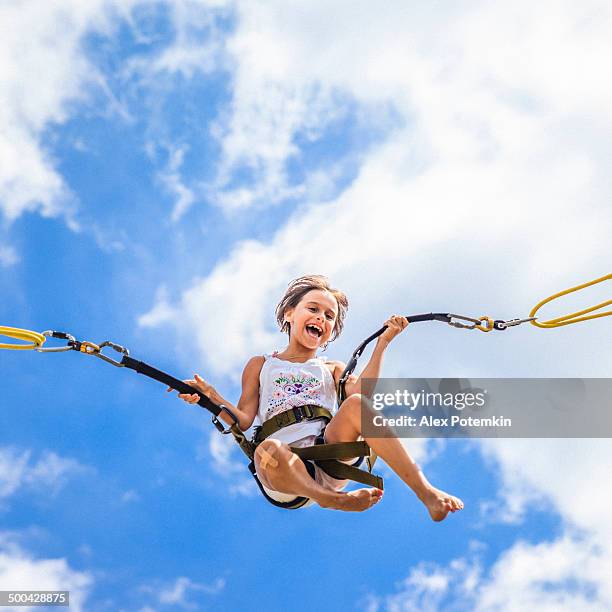 little girl bungee jumping at trampoline - bungee cord stock pictures, royalty-free photos & images