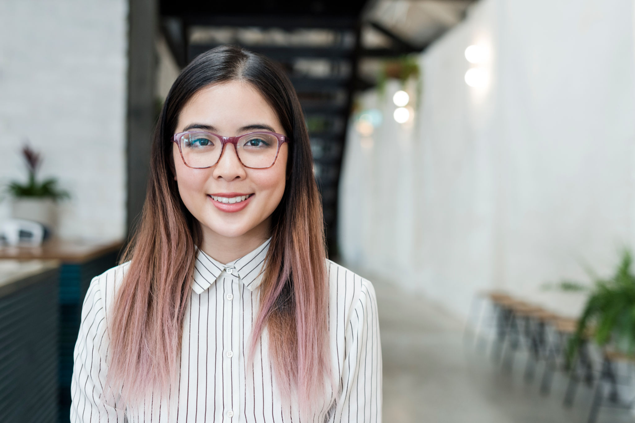 Trendy young Asian businesswoman with pink hair and glassses Trendy young Asian businesswoman with pink hair and glassses