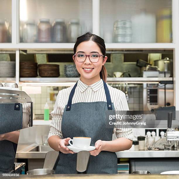 young female asian barista holding coffee at cafe counter - sydney cup stock pictures, royalty-free photos & images