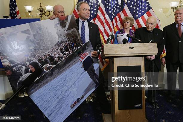 Sen. Tim Kaine holds news photographs of Syrians during a news conference with national religious leaders to respond to attempts at vilifying...