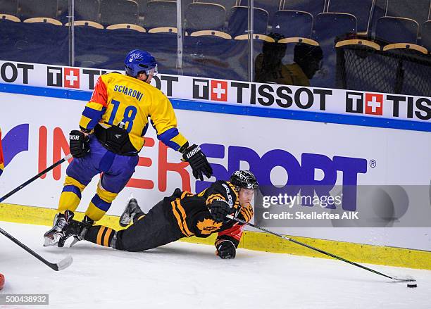 Alexander Urbom of Skelleftea AIK handels the puck as Gregory Sciaroni of HC Davos looses balance during the Champions Hockey League quarter final...