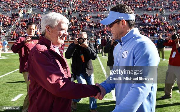 Head coach of the Virginia Tech Hokies Frank Beamer shakes hands with head coach of the North Carolina Tar Heels Larry Fedora prior to the game at...