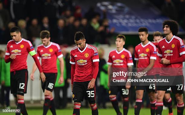 Manchester United's players look dejected as they leave the pitch after the UEFA Champions League Group B second-leg football match VfL Wolfsburg vs...