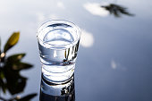Refreshing water in transparent glass with reflection against bl