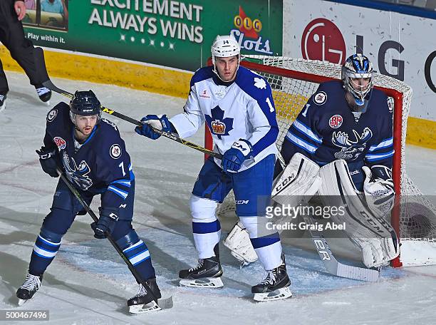 Goalie Eric Comrie and Josh Morrissey of the Manitoba Moose battle for crease space with Josh Levio of the Toronto Marlies during AHL game action on...