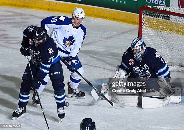 Goalie Eric Comrie and Jay Harrison of the Manitoba Moose scramble for a loose puck with Richard Panik of the Toronto Marlies during AHL game action...