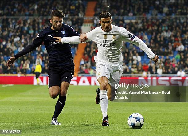 Cristiano Ronaldo of Real Madrid competes for the ball with Erdal Rakip of Malmo FF during the UEFA Champions League Group A match between Real...