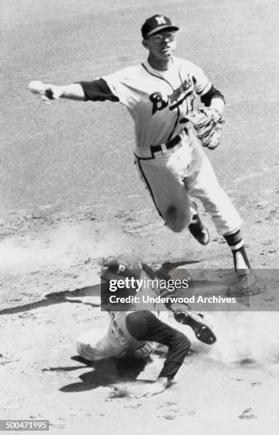 Pittsburgh Pirates outfielder Roberto Clemente is forced out at second base as Braves shortstop Roy McMillan relays the throw to first on a double...