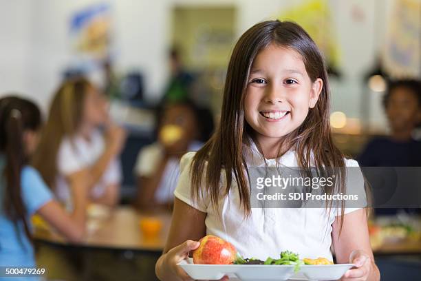 carina ispaniche studente di scuola elementare con vassoio di cibo caffetteria - cafeteria foto e immagini stock