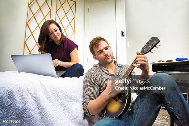 young couple writing a song in the bedroom - mandolin stock pictures, royalty-free photos & images