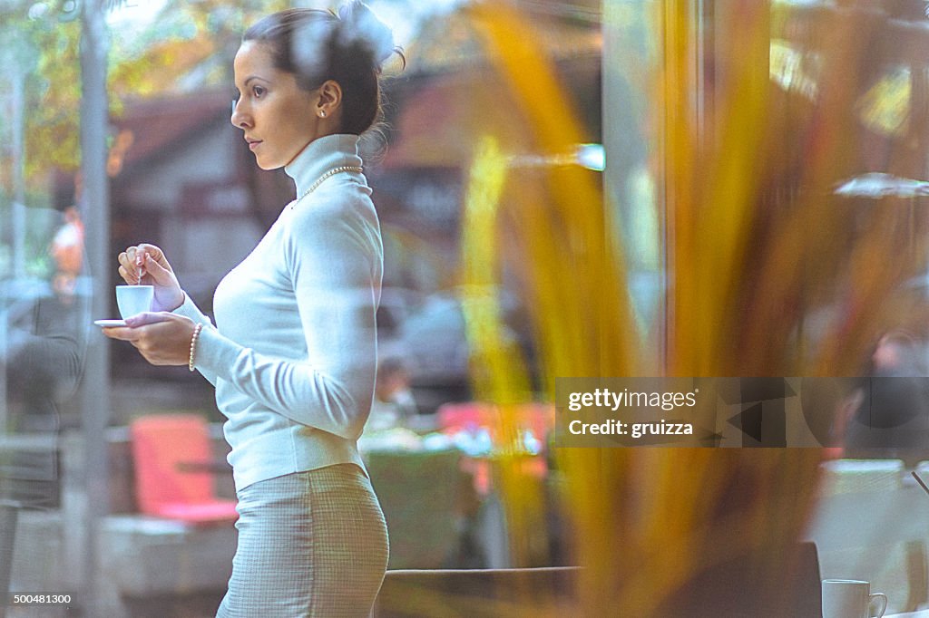 Schöne, elegante Frau Genießen Sie frische Tasse Kaffee im Café