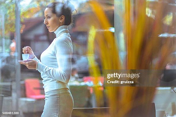 beautiful, elegant woman enjoying fresh cup of coffee at cafe - luxury city break stock pictures, royalty-free photos & images