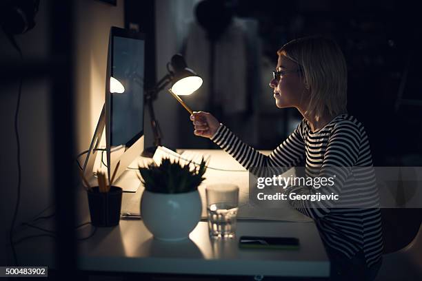 late night in the office - desk lamp stockfoto's en -beelden