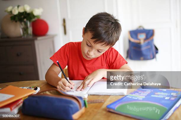 a 7 years old boy doing his homework - 6 7 years - fotografias e filmes do acervo