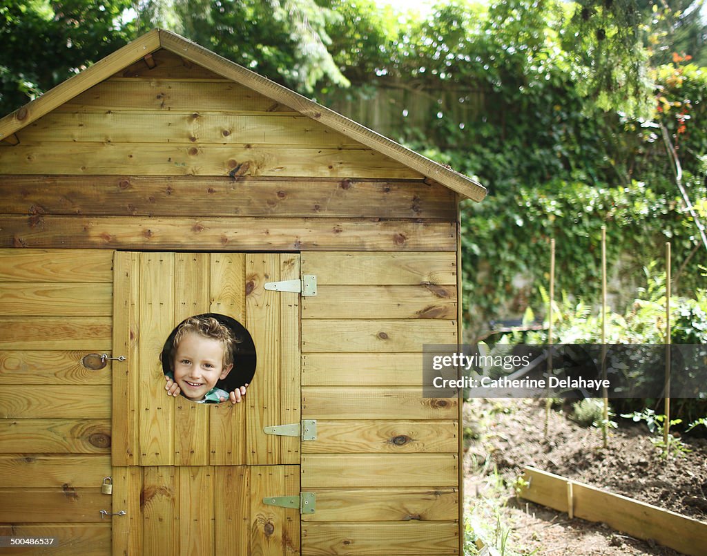 A 4 years old boy in a garden cabin