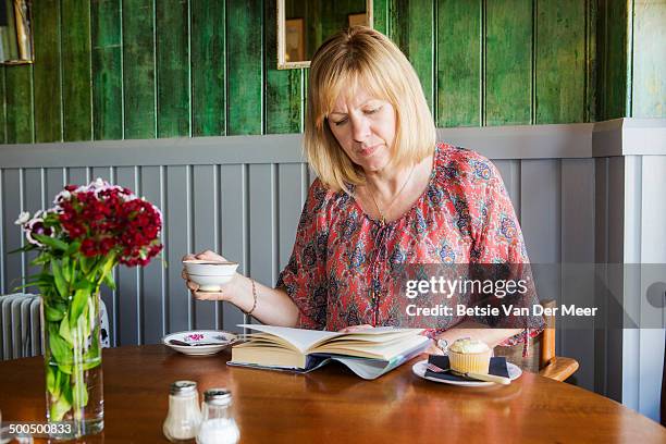 senior woman ready book in cafe. - bistro stock pictures, royalty-free photos & images