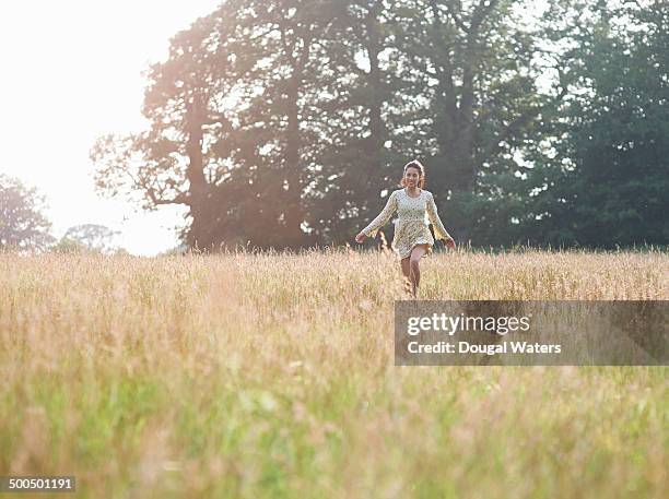 woman skipping through meadow - skip ストックフォトと画像