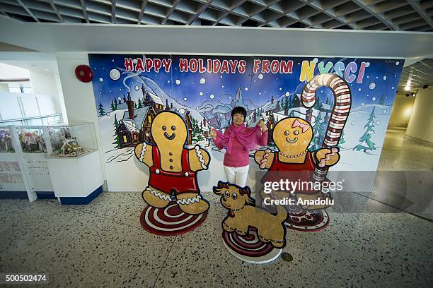 Woman poses near the Gingerbread Lane Village created by Chef Jon Lovitch is being displayed at the New York Hall of Science in the New York, NY, USA...