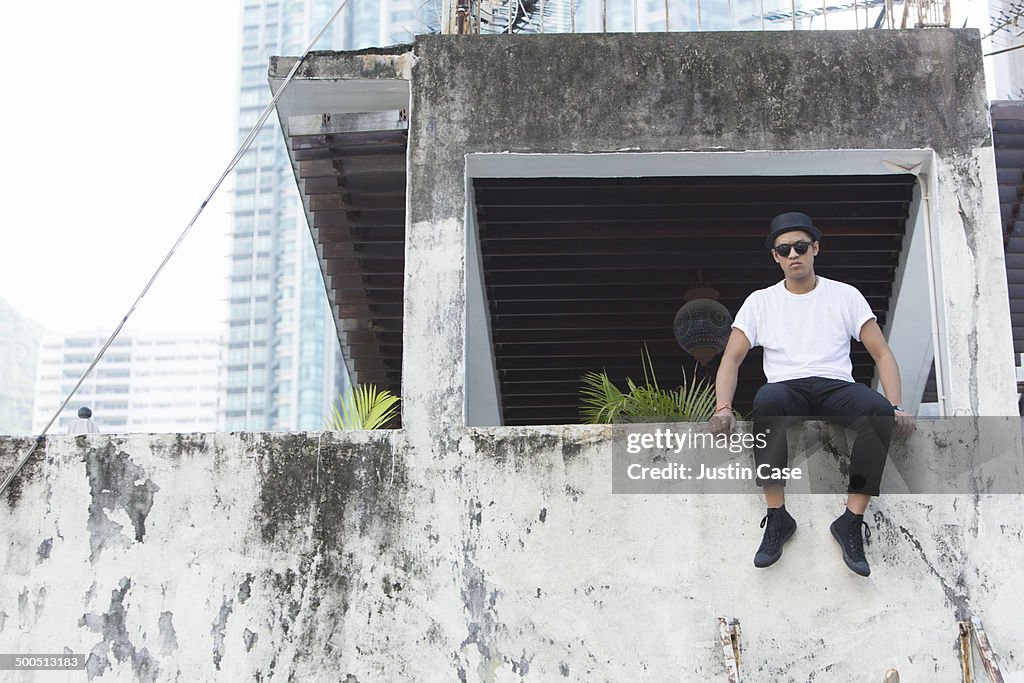 Man sitting on the edge of a balcony