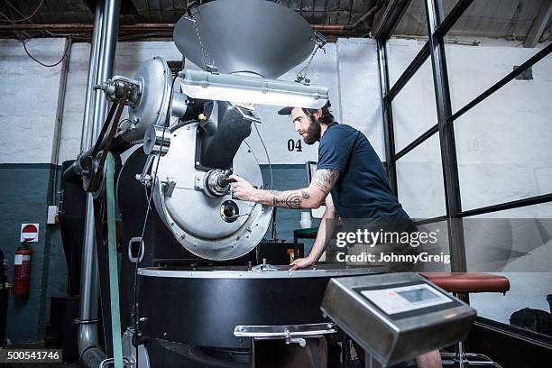 man using machinery in coffee roasting warehouse - coffee manufacturing stock pictures, royalty-free photos & images