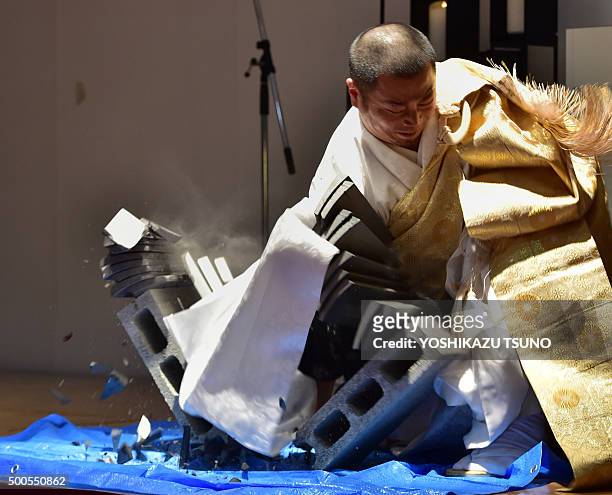 Contestant Taigen Yokoyama demonstrates his technique in the Japanese martial art of karate by breaking a pile of 10 tiles with his bare right hand,...