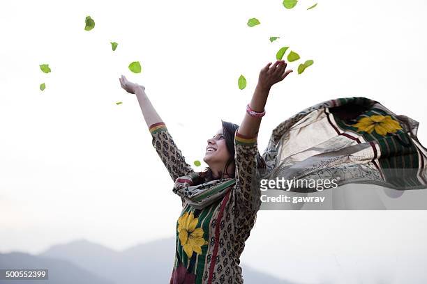 glückliche junge frau mit fliegenden leafs in eine richtung himmel. - india freedom stock-fotos und bilder