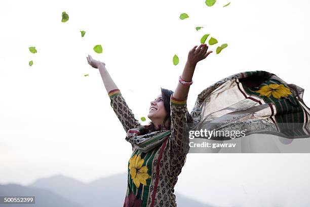 happy young woman flying leafs in air towards sky. - india woman stock pictures, royalty-free photos & images