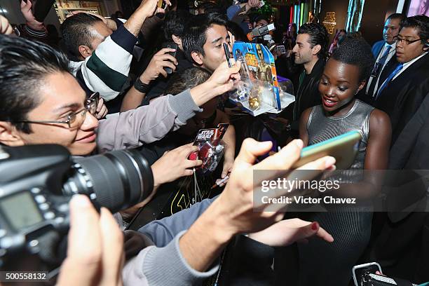 Actress Lupita Nyong'o signs autographs and takes selfies with fans during the "Star Wars: The Force Awakens" Mexico City premiere fan event at...