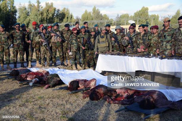 Members of the Afghan military stand near bodies of Taliban militants wearing Afghan army uniforms who were killed during clashes against security...