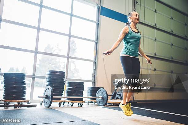 mature woman jumping rope in gym setting - jump rope bildbanksfoton och bilder