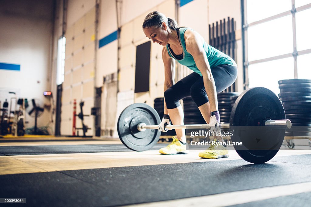 Mature Woman Lifting Weights in Gym Setting