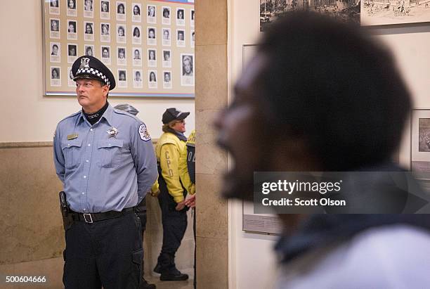 Protestors demonstrate outside the city council chambers y as Chicago Mayor Rahm Emanuel addresses a special session of the City Council as his...