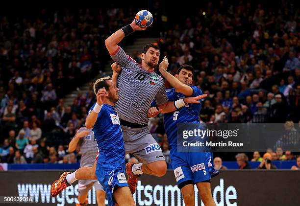 Pascal Hens and Drasko Nenadic of Hamburg challenge Jakov Gojun of Berlin during the DKB Bundesliga handball match between HSV Handball and Fuechse...