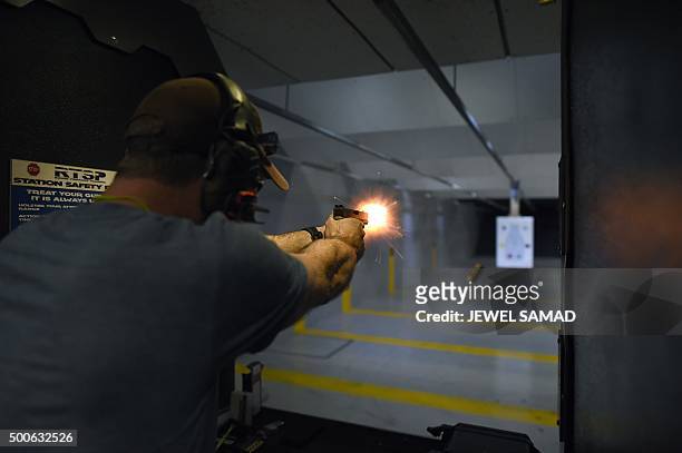 Man fires a handgun as he trains at the RTSP shooting range in Randolph, New Jersey on December 9, 2015. US President Barack Obama called for tougher...
