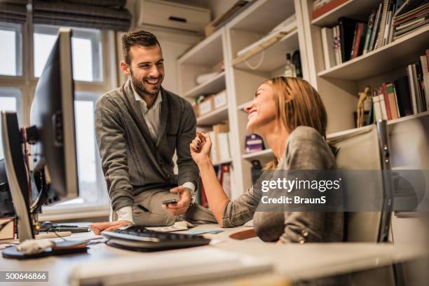 young cheerful business colleagues flirting at corporate office. - work romance stock pictures, royalty-free photos & images