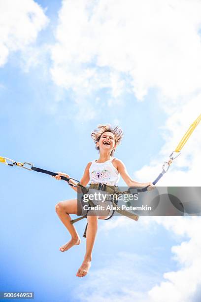 little girl bungee jumping at trampoline - alex potemkin or krakozawr latino fitness stock pictures, royalty-free photos & images