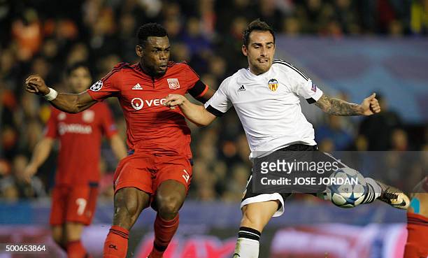 Lyon's Cameroonian defender Henri Bedimo vies with Valencia's forward Paco Alcacer during the UEFA Champions League football match Valencia CF vs...