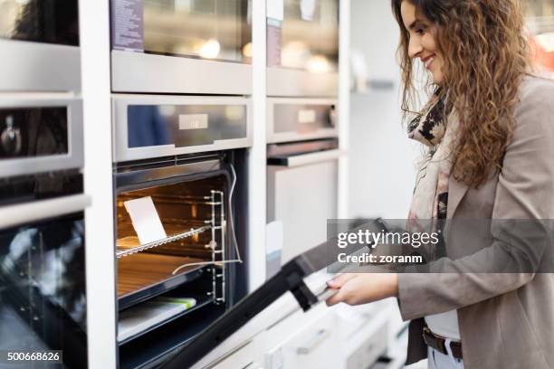 woman buying stove - electronic products stockfoto's en -beelden