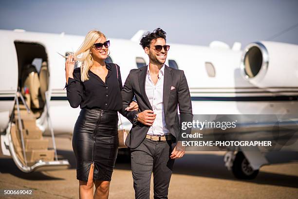 business couple leaving private airplane - jet black wings stock pictures, royalty-free photos & images