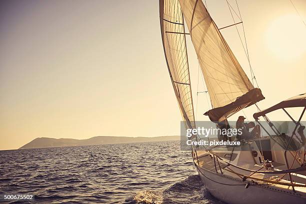 shot of a young couple spending time together on a yacht - affluent stock pictures, royalty-free photos & images