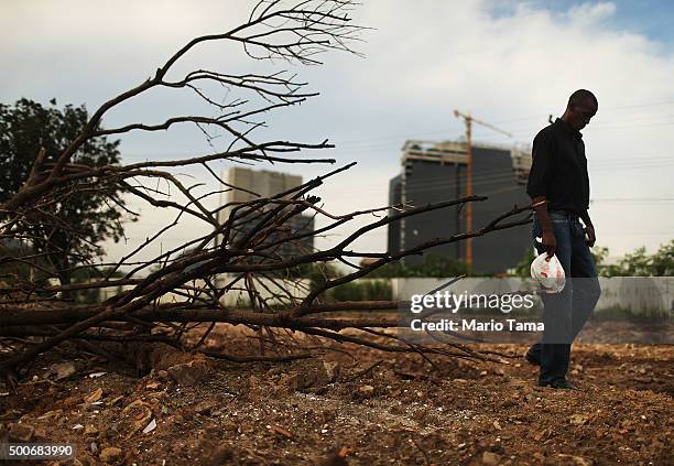 Former resident Sergio Coelho walks with his lunch on the grounds of his former property in the mostly demolished Vila Autodromo favela community,...