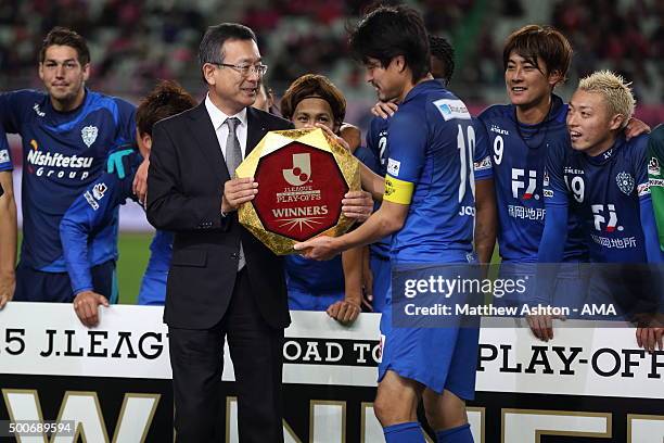 Mitsuru Murai the J League Chairman presents the J.League Play Offs Winners Shield Trophy to Hisashi Jogo of Avispa Fukuoka during the J2 Promotion...