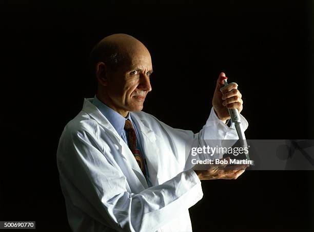 Special Report: Closeup portrait of Dr. Graham Trout with multi-pipette used for loading samples into a 96-well immunoassay plate during studio photo...