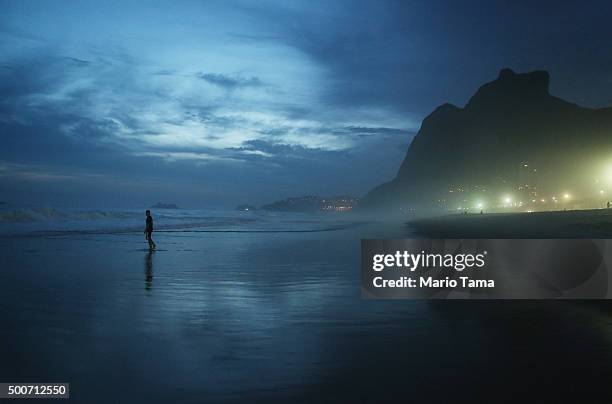 Man walks at dusk along Sao Conrado beach on December 9, 2015 in Rio de Janeiro, Brazil. The city is set to host the Rio 2016 Olympic Games next...