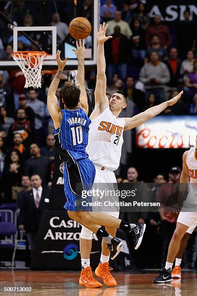 Evan Fournier of the Orlando Magic attempts a last second shot over Alex Len of the Phoenix Suns during the NBA game at Talking Stick Resort Arena on...