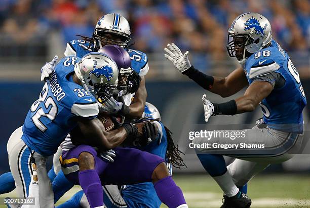 Adrian Peterson of the Minnesota Vikings is tackled by James Ihedigbo, Josh Bynes, and Rashean Mathis of the Detroit Lions at Ford Field on October...