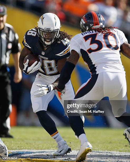 Melvin Gordon of the San Diego Chargers runs with the ball as David Bruton of the Denver Broncos defends during a game at Qualcomm Stadium on...