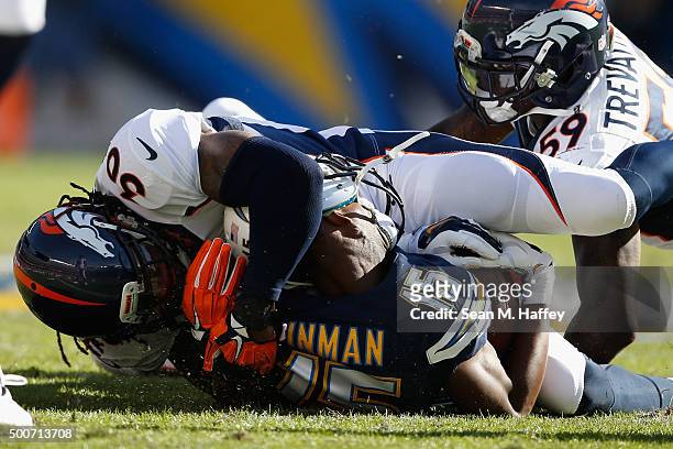 David Bruton of the Denver Broncos and Danny Trevathan of the Denver Broncos tackle Dontrelle Inman of the San Diego Chargers during a game at...