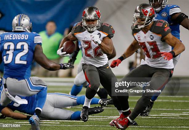 Doug Martin of the Tampa Bay Buccaneers looks to avoid the tackle by James Ihedigbo of the Detroit Lions at Ford Field on December 07, 2014 in...