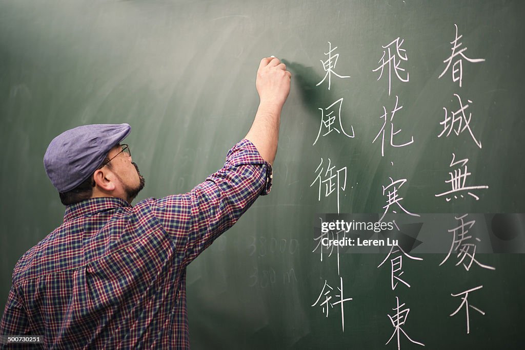 Teacher writing Chinese poem on board
